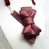 red bow tie, vertical bow tie, luxury womens tie, handmade tie, statement neckwear, unique bow tie, elegant tie for women, double-sided tie, brooch tie, pendant tie, rose wine tie, wedding accessory, business fashion, fashion necktie, Rūta Piekurienė design, artistic tie, unisex tie, special occasion tie, decorative tie, floral pattern tie, modern bow tie, Lithuanian handmade, pre-tied bow tie, gift for her