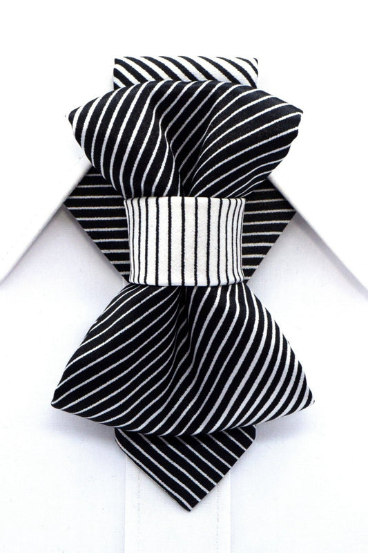 Bow tie with black and white strips, Elegant necktie, Hopper tie black and white Woman wearing a black and white striped fabric necktie accessory over a white collared shirt Close-up of a stylish bow-tie style neck accessory on a oman, featuring black and white stripes
Fashionable woman with an updo hairstyle, subtly looking away, showcasing a striped necktie choker Handmade textile neck accessory with geometric black and white stripes, worn by a model in a white shirt