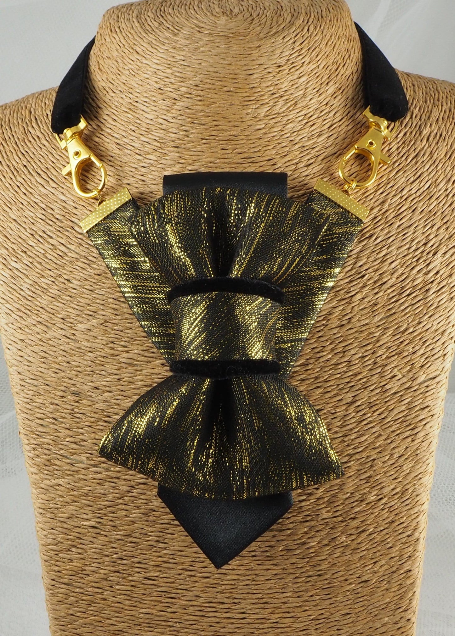 black gold womens necktie, luxury necktie for women, handmade necktie, statement accessory, elegant womens tie, unique gift for her, versatile neckwear, brooch pendant tie, modern necktie, Rūta Piekurienė design, Lithuanian handmade tie, formal accessory women, artistic necktie, special occasion tie, fashion tie for women, pre tied womens necktie, designer neckwear, black and gold tie, edgy womens fashion, dressy necktie
