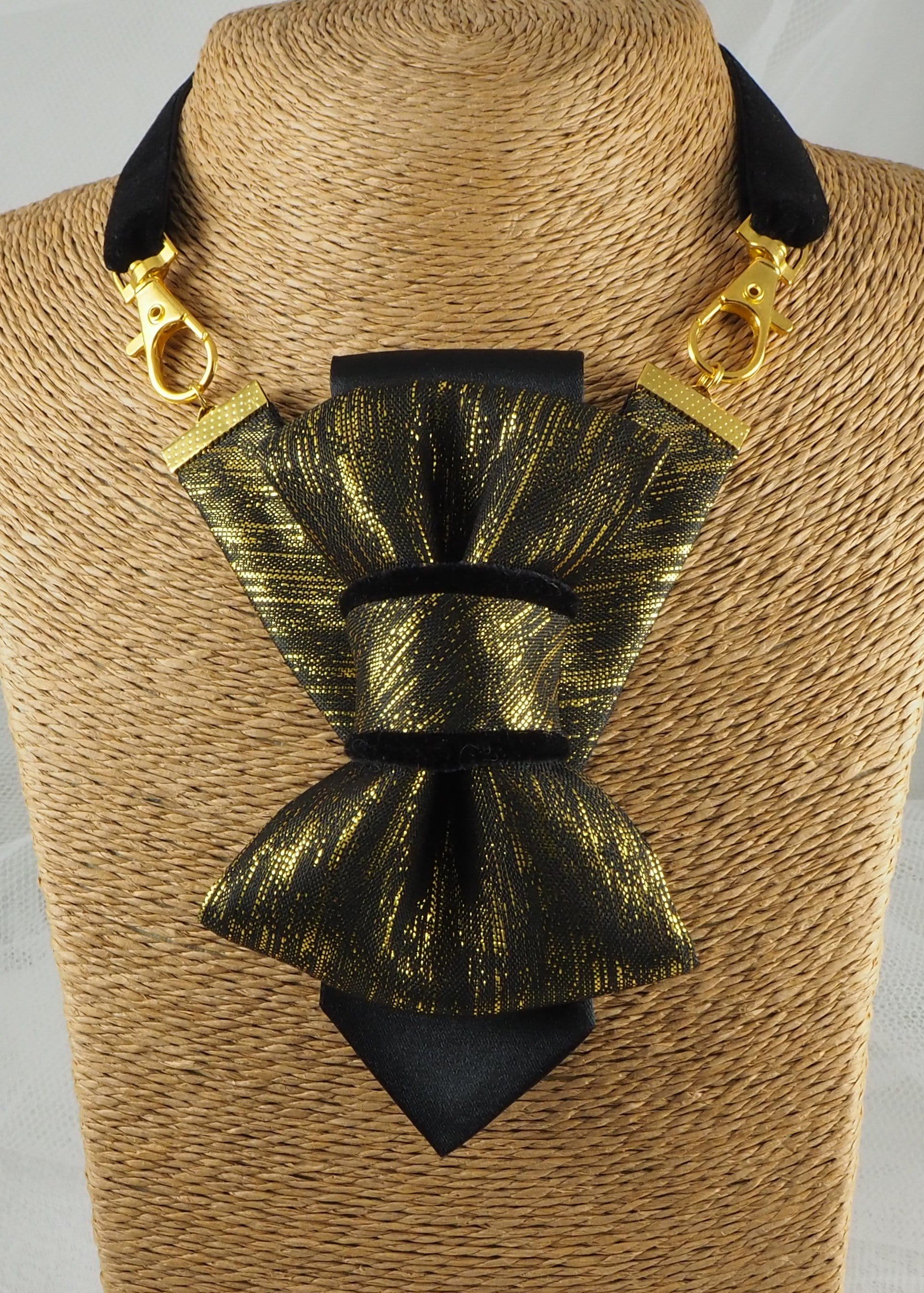 black gold womens necktie, luxury necktie for women, handmade necktie, statement accessory, elegant womens tie, unique gift for her, versatile neckwear, brooch pendant tie, modern necktie, Rūta Piekurienė design, Lithuanian handmade tie, formal accessory women, artistic necktie, special occasion tie, fashion tie for women, pre tied womens necktie, designer neckwear, black and gold tie, edgy womens fashion, dressy necktie