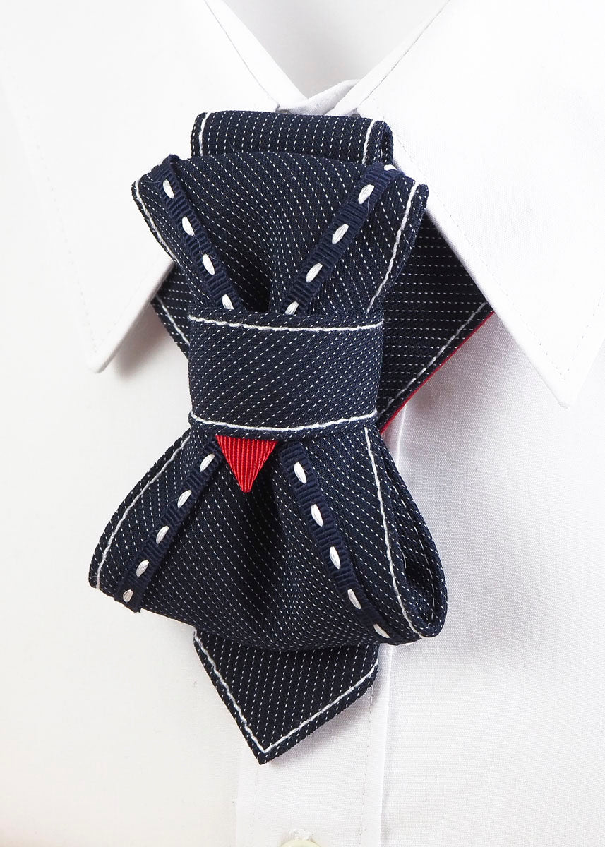 Handmade luxury tie "Wilson" with layered navy design and red accent

Unique wedding tie for men with white stitching and folded structure

Artistic necktie for groom – navy with fine pinstripes and red detail

"Wilson" designer necktie with geometric knot and bold statement look

Formal men’s accessory – navy handmade tie with contrast thread

Unisex sculptural tie with modern twist for weddings and performances

Luxury groom tie by Rūta Piekurienė in deep blue and white stitching

Close-up of folded handm