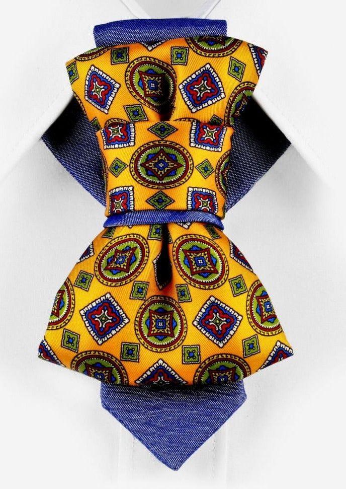 HOPPER TIE THE SUNNY ARABESCO Yellow patterned necktie, blue shirt, geometric design, men's fashion, stylish accessory, unique tie, artistic, colorful, handcrafted, elegant, Finnish design inspiration.
