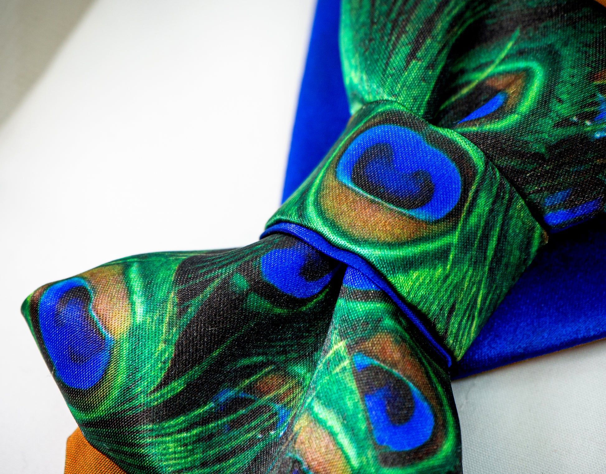 BOW TIE HOPPER TIE PEACOCK Woman wearing a stylish necklace with peacock feathers and a gray blazer peacock feather necklace, statement bow tie necklace, handmade silk accessory, green blue peacock pattern jewelry, artistic neckpiece, elegant women accessory, unique designer necklace, luxury handmade jewelry, modern bow necklace, bold statement piece, peacock motif fashion, gift for her unique jewelry, sustainable handmade accessory, artisan neckwear, teal green fashion accessory